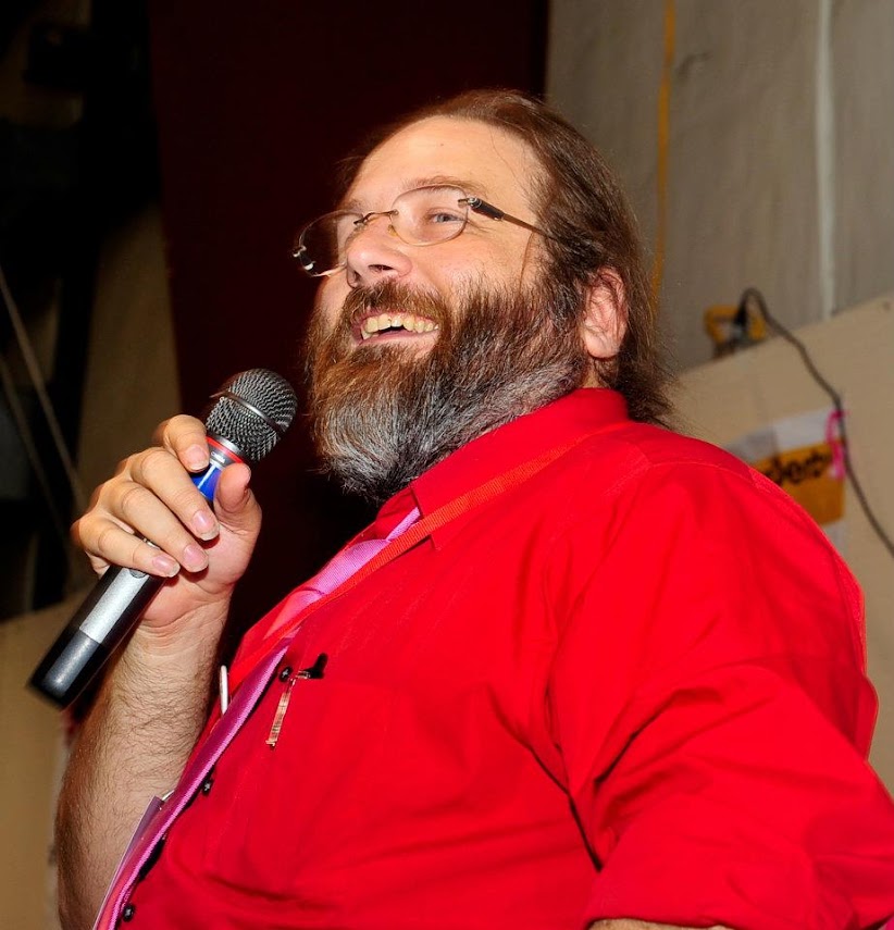 Big Daddy Voodoo laughing with a microphone while hosting a live event
